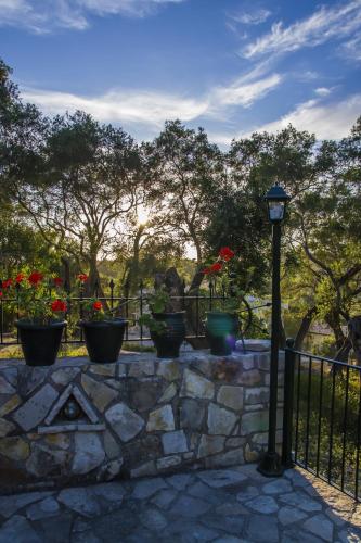 a fence with potted plants and a street light at Su La Strata Villa by CorfuEscapes in Gaios