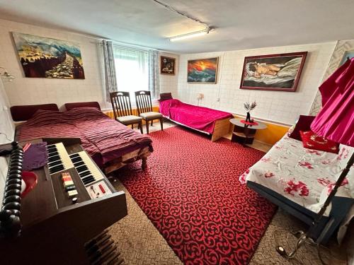 Un dormitorio con una cama y un piano sobre una alfombra roja en Piekalne, en Kalnieši