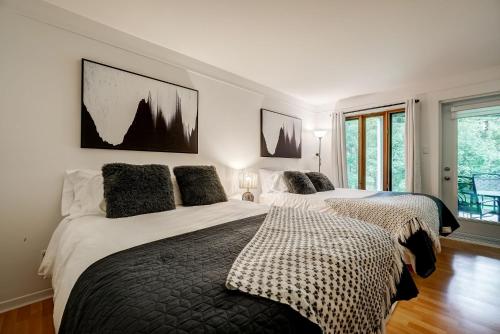 a bedroom with two beds and a window at Le SEVEN in Mont-Tremblant