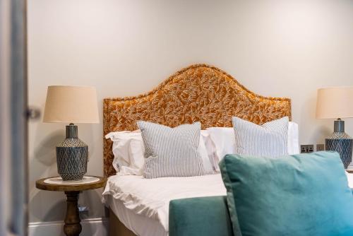 a bedroom with a bed with white and blue pillows at Old Abbey House in Abingdon
