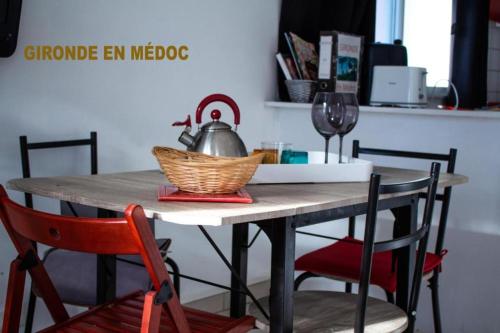 stół jadalny z czajnikiem i krzesłami w obiekcie Bureau Lesparre-médoc, Les Pins w mieście Lesparre-Médoc