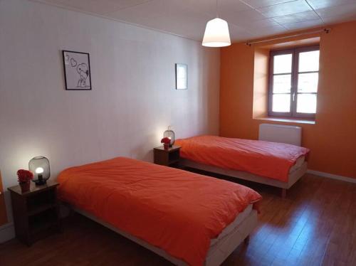 a bedroom with two beds and a window at Appartement cosy avec son charme ancien. in Saint-Claude