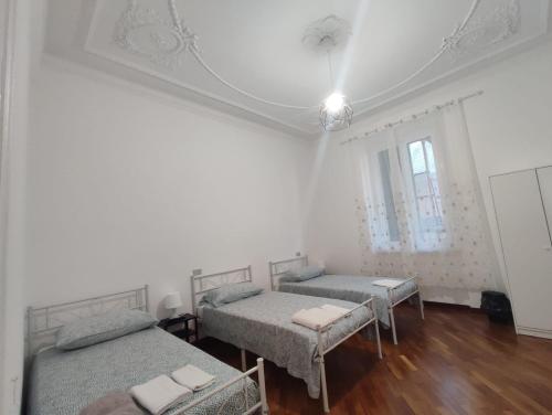 Dieses weiße Zimmer verfügt über 2 Betten und eine Decke. in der Unterkunft Lucia appartamento uso esclusivo - Aeroporto Genova Sestri Ponente in Genua
