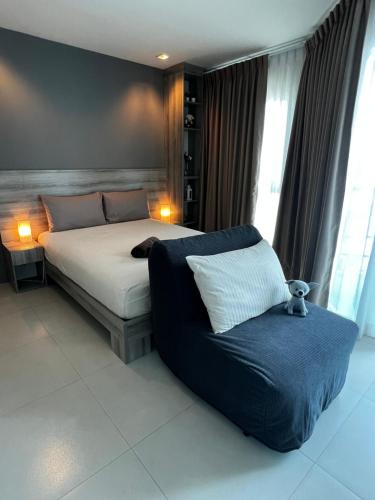 メーピンにあるGrandblue Condominium#702 Seaview TopFloor MaePim Rayongのベッドルーム(大型ベッド1台、ソファ付)