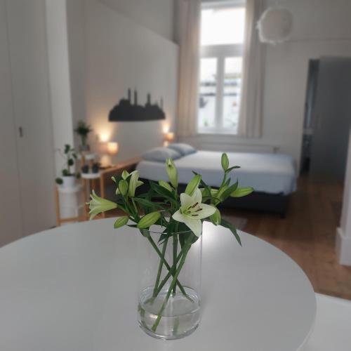 a vase with flowers on a table in a room at Bennestay in Ghent