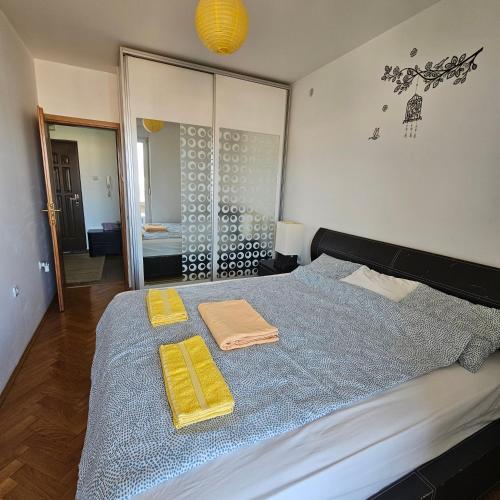 ein Schlafzimmer mit einem Bett mit zwei Handtüchern darauf in der Unterkunft Sunshine Apartment Podgorica in Podgorica
