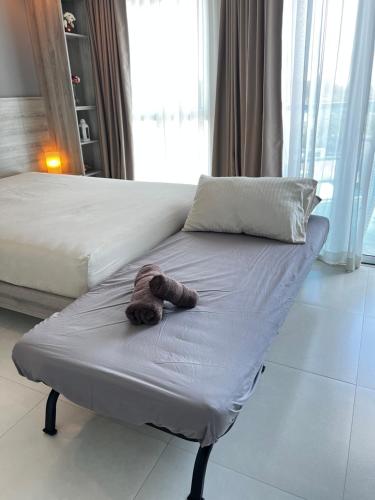 a stuffed teddy bear laying on a bed at Grandblue Condominium#702 Seaview TopFloor MaePim Rayong in Mae Pim