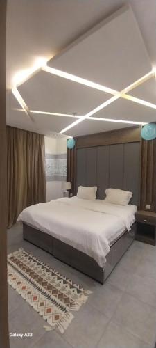 - une chambre avec un grand lit blanc et des lumières bleues dans l'établissement مكارم الدار, à La Mecque