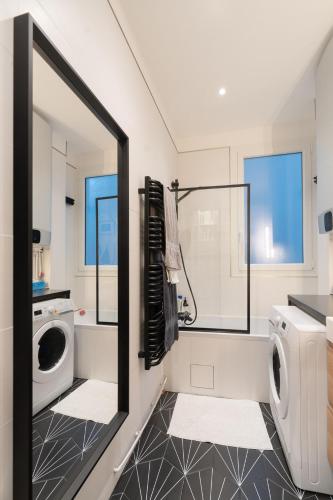 La salle de bains est pourvue d'un lave-linge et d'un miroir. dans l'établissement 3 p. 47m2 au pied de Montmartre - Idéal JO 2024, à Paris