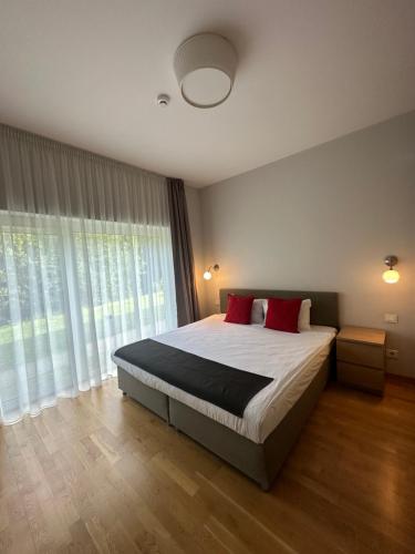 a bedroom with a bed and a large window at ForRest Apartments in Vilnius