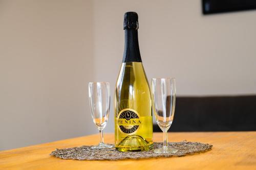 a bottle of champagne on a table with two glasses at Apartments Luxury AD in Jesenice