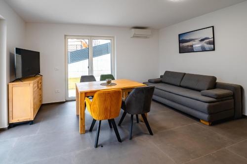 a living room with a table and a couch at Apartments Luxury AD in Jesenice