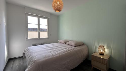 une chambre blanche avec un lit et une fenêtre dans l'établissement La Villa des Lilas, à Saint-Valery-sur-Somme