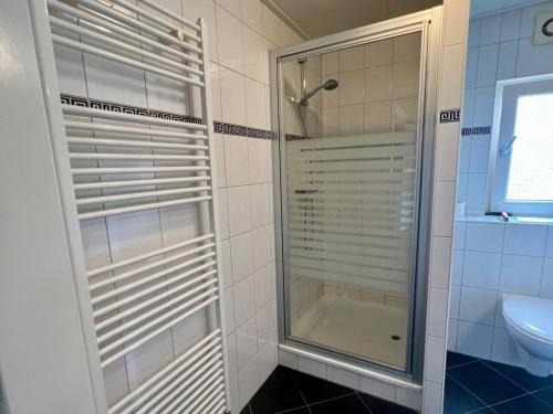 a shower with a glass door in a bathroom at WHITE BEACH HOUSE in Breskens