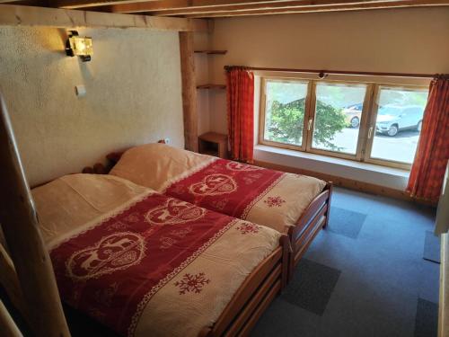 a bedroom with two beds and a window at Chalet Le Grand Méan in Bonneval-sur-Arc