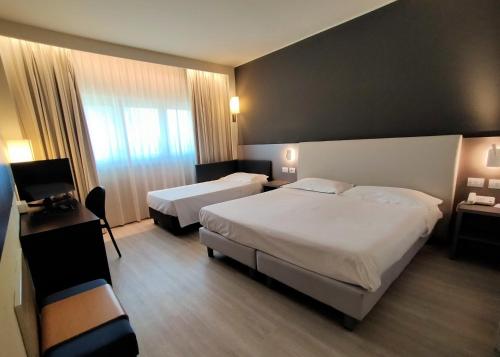 a hotel room with two beds and a television at The Sydney Hotel in Bologna