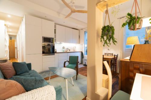 un salon et une cuisine avec un canapé et une table dans l'établissement 3 p. 47m2 au pied de Montmartre - Idéal JO 2024, à Paris