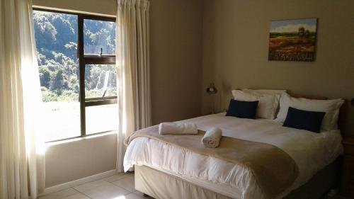 a bedroom with a large bed with a window at Ledges Retreat in Bergville