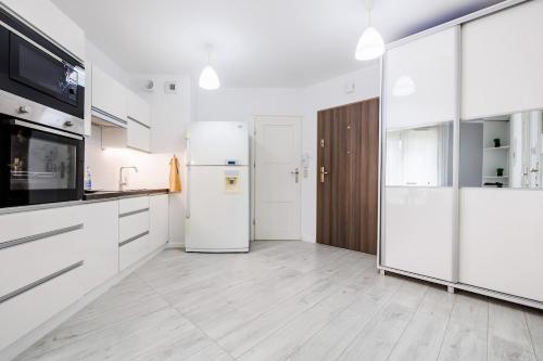 una cocina con electrodomésticos blancos y armarios blancos en Apartamenty Zamkowe- High Standard Apartment, en Rzeszów