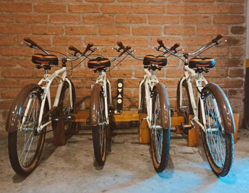 three bikes parked in front of a brick wall at Hotel Laghetto Fratello in Gramado