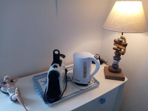 una mesa con tetera y una lámpara. en LE PETIT CABOURG de LA COUR NORMANDE Studio coeur de ville -1 à 2 personness, en Cabourg