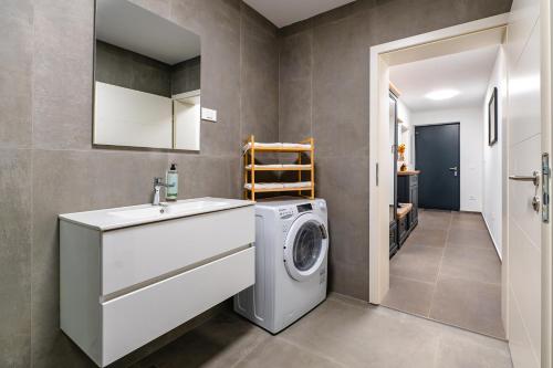 a bathroom with a washing machine and a sink at Apartments Luxury AD in Jesenice