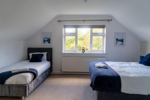 um quarto com 2 camas e uma janela em Spacious home sleeps 13 guests Shirley em Solihull