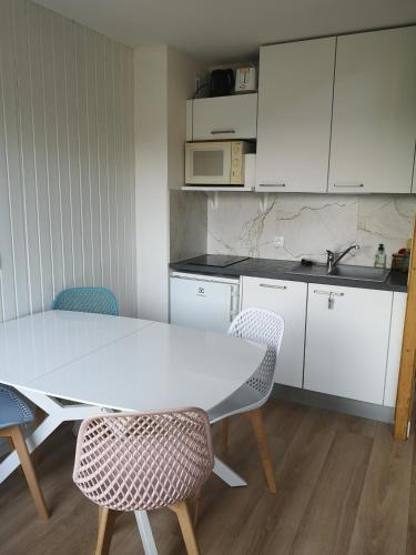 a kitchen with a white table and two chairs at Appartement lumineux, 4-6 personnes, refait à neuf in Les Gets