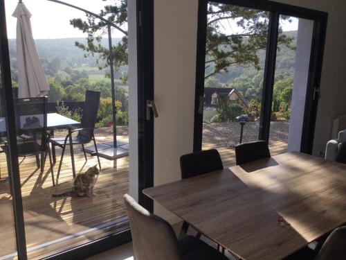 une salle à manger avec une table et un chat assis sur une terrasse dans l'établissement Savigny view, à Savigny-lès-Beaune