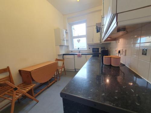 a kitchen with a black counter top in a room at 63B Willesden Lane Two Bed Apartment in London