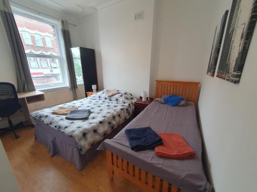 a bedroom with two beds and a window at 63B Willesden Lane Two Bed Apartment in London