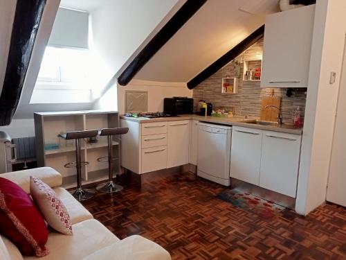 a kitchen with white cabinets and a couch in a room at La Mole apartment in Turin