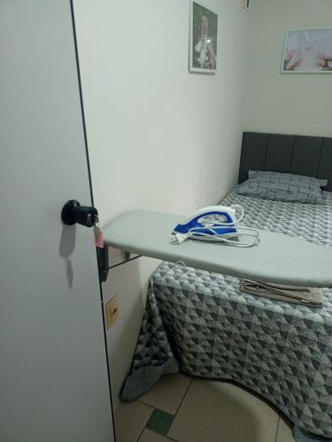 a bed in a room with a bed with a table at quarto 05 solteiro aconchegante a 2 km de Alphaville in Barueri