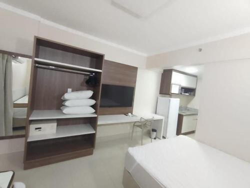 een witte kamer met een bed en een keuken bij Spazzio DiRoma com Parque incluso! in Caldas Novas