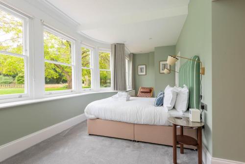 a bedroom with a large bed and windows at Old Abbey House in Abingdon