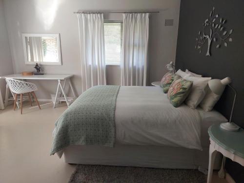 a bedroom with a bed and a table and a desk at The Red Gate Suite for Garden Route tranquility in George