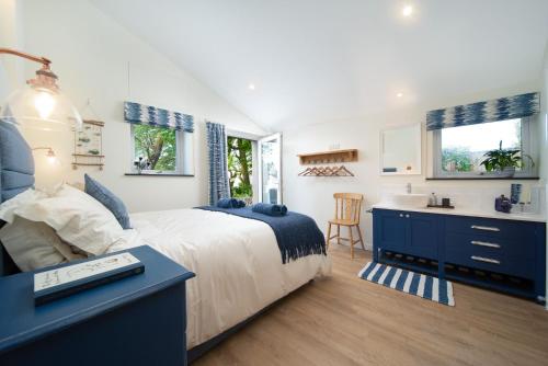 a bedroom with a bed and a desk and a sink at Courtyard Cottage in Barnstaple