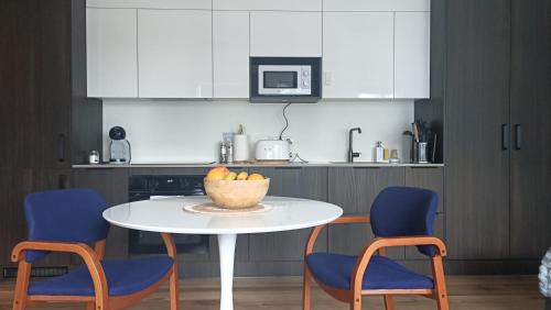 a kitchen with a table with chairs and a bowl of fruit at Ocean View Suite near Sky Lagoon in Reykjavík