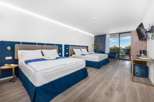 a hotel room with two beds and a television at Hotel Del Mar Emotion in Pula