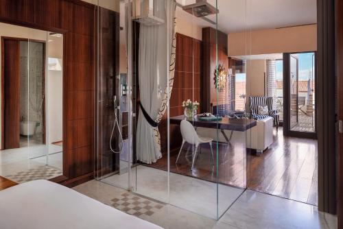 Repubblica Firenze Luxury Apartments | UNA Esperienze في فلورنسا: غرفة نوم مع غرفة مع طاولة وغرفة طعام