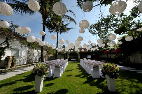 a row of tables with white chairs and lights at Uma Sapna Seminyak in Seminyak