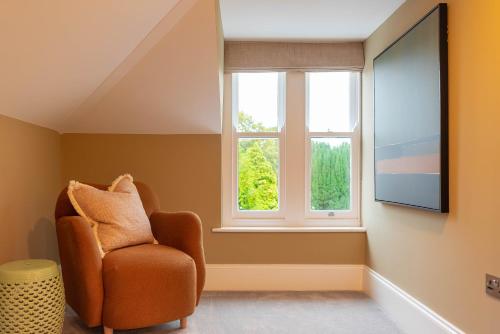a living room with a chair and a large window at Old Abbey House in Abingdon
