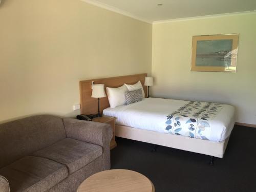 a hotel room with a bed and a couch at Bell Tower Inn in Ballarat