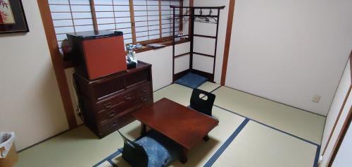 Zimmer mit einem Schreibtisch, einem TV und einem Stuhl in der Unterkunft Kyo-no-sato 京の里 in Kyoto