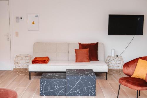 a living room with a white couch and a tv at K&Y suites 3 Brussels airport 500m! in Zaventem