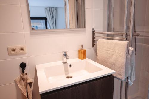 uma casa de banho com um lavatório branco e um espelho. em K&Y suites 3, 500m to Brussels airport em Zaventem