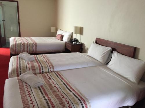 two beds in a hotel room next to each other at Bell Tower Inn in Ballarat