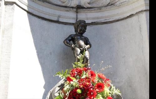 a statue of a boy and a bunch of flowers at K&Y suites 3 Brussels airport 500m! in Zaventem