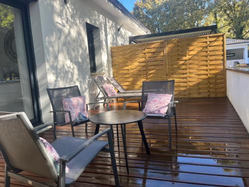 un groupe de chaises et une table sur une terrasse dans l'établissement Salles, Maison à 30 min d'Arcachon, à Salles