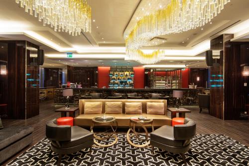 a lobby with a couch and a bar with chandeliers at Hilton Istanbul Bomonti in Istanbul